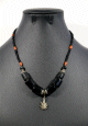 Collier ethnique artisanal 6 pierres cylindriques noires 15x14mm agrémentées d'une breloque en forme de palmier Collier ethnique artisanal 6 pierres cylindriques noires 15x14mm agrementees d'une breloque en forme de palmier