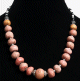Collier ethnique artisanal imitation boules de corail rose agencées de perles argentées, noires et blanches Collier ethnique artisanal imitation boules de corail rose agencees de perles argentees, noires et blanches